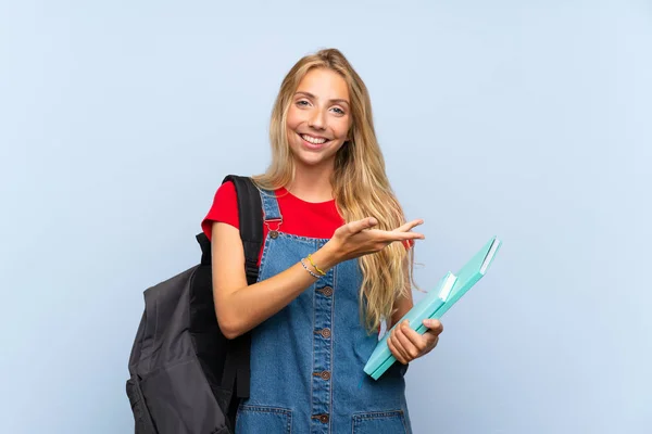 Jovem Loira Estudante Mulher Sobre Isolado Parede Azul Estendendo Mãos — Fotografia de Stock