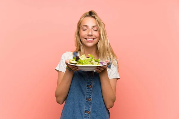 Gelukkige Blonde Jonge Vrouw Met Salade Geïsoleerde Roze Muur — Stockfoto