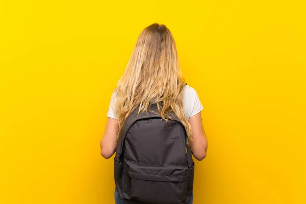 Jovem Loira Sobre Fundo Amarelo Isolado Com Mochila — Fotografia de Stock