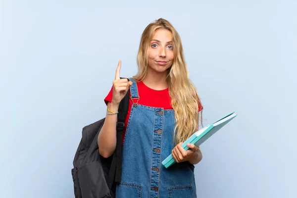 Jonge Blonde Student Vrouw Geïsoleerde Blauwe Muur Wijzend Met Wijsvinger — Stockfoto