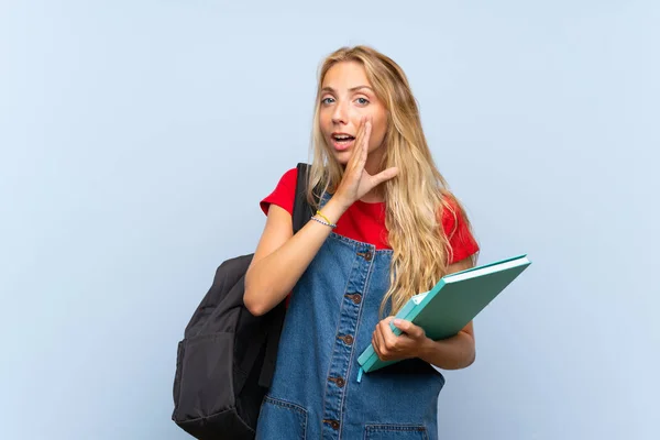 Młoda Blondynka Studentka Białym Niebieskim Ścianie Szeptem Coś — Zdjęcie stockowe