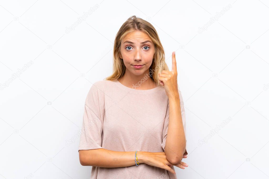 Blonde young woman over isolated white background pointing with the index finger a great idea