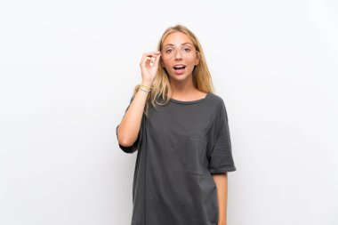 Gözlük lü izole beyaz arka plan üzerinde Sarışın genç kadın ve şaşırttı