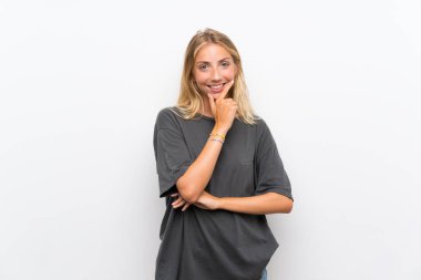 Izole beyaz arka plan üzerinde sarışın genç kadın yan bakıyor