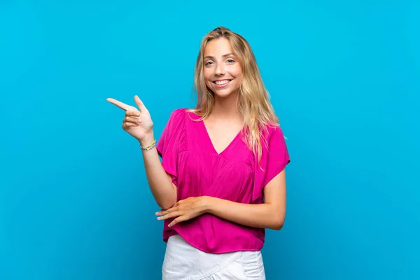 Blond Ung Kvinna Över Isolerad Blå Bakgrund Pekfingret Sidan — Stockfoto