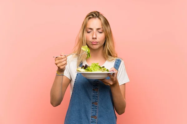 Blonde Jonge Vrouw Met Salade Geïsoleerde Roze Muur — Stockfoto