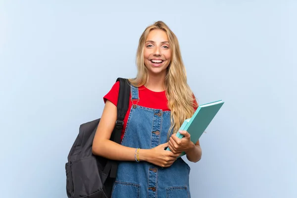 Junge Blonde Studentin Über Isolierte Blaue Wand Mit Überraschendem Gesichtsausdruck — Stockfoto