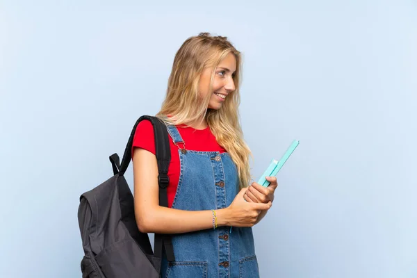 Jovem Loira Estudante Mulher Sobre Isolado Parede Azul Olhando Para — Fotografia de Stock