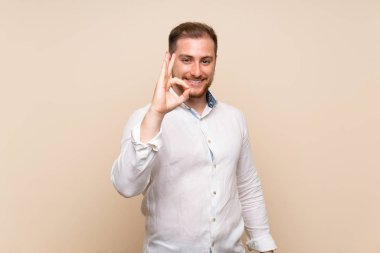 Izole arka plan üzerinde Blonde adam parmakları ile ok işareti gösteren