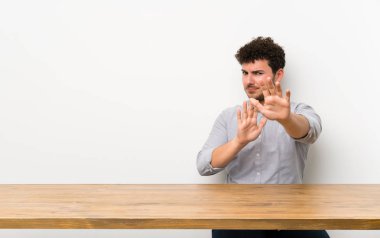 Bir masa sinir ön ellerini germe ile genç adam