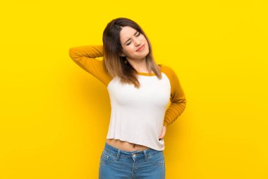 Güzel genç kadın üzerinde izole sarı duvar ile neckache
