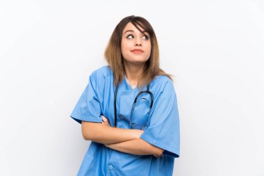Omuzları kaldırarak beyaz duvar üzerinde genç hemşire kadın şüphe jest yapma