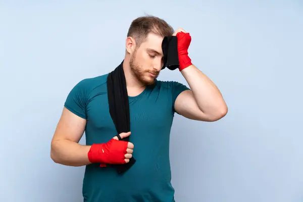 Blonde sport man over blue wall — Stock Photo, Image