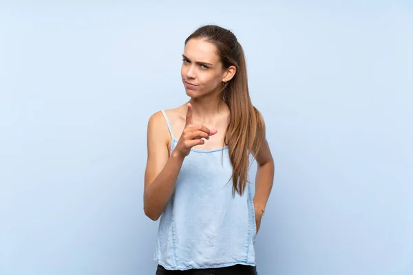 Mujer Joven Sobre Fondo Azul Aislado Frustrado Apuntando Hacia Frente — Foto de Stock