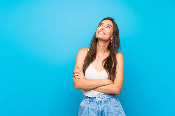 Giovane Donna Isolato Sfondo Blu Guardando Verso Alto Sorridendo — Foto Stock