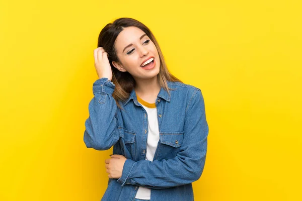 黄色の背景の上の若い女性笑い — ストック写真