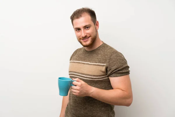 英俊的男人在孤立的白色墙壁上拿着热咖啡杯 — 图库照片