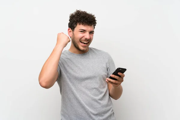 Man Met Krullend Haar Geïsoleerde Muur Met Behulp Van Mobiele — Stockfoto