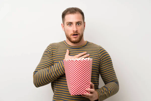 Przystojny Człowiek Białym Ścianie Trzymając Miskę Popcorns — Zdjęcie stockowe