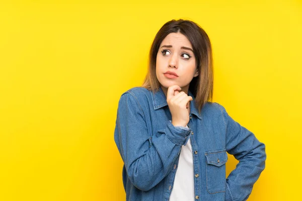 Jonge Vrouw Gele Achtergrond Hebben Twijfels Met Verwarring Gezichtsuitdrukking — Stockfoto