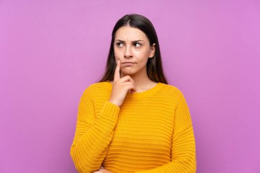 İzole edilmiş mor arka plan fikri olan genç bir kadın.