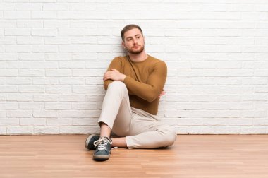 Sarışın adam yerde oturan bir fikir düşünme