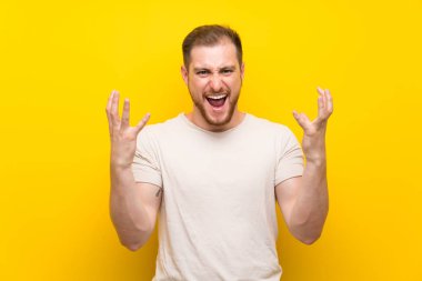 Sarı arka plan üzerinde yakışıklı adam mutsuz ve bir şey ile sinirli