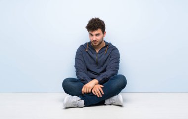 Üzgün ve depresyonda ifade ile katta oturan genç adam