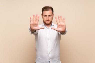 İzole arka plan üzerinde sarışın adam stop jest yapma ve hayal kırıklığına