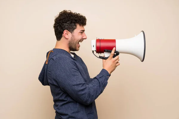 Man Met Krullend Haar Geïsoleerde Muur Schreeuwen Door Een Megafone — Stockfoto