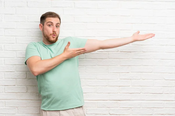 Bionda Uomo Oltre Muro Mattoni Che Estende Mani Lato Invitare — Foto Stock