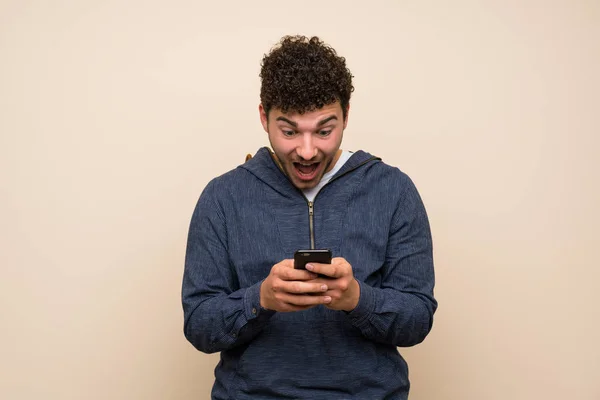 Man Met Krullend Haar Geïsoleerde Muur Verrast Het Verzenden Van — Stockfoto