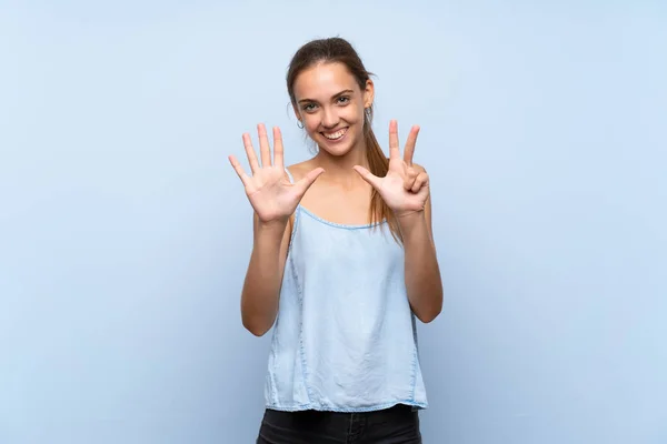 Νεαρή Γυναίκα Πάνω Από Απομονωμένο Μπλε Φόντο Καταμέτρηση Οκτώ Δάχτυλα — Φωτογραφία Αρχείου