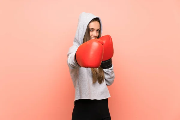 Junge Sportlerin vor isoliertem rosa Hintergrund mit Boxhandschuhen — Stockfoto