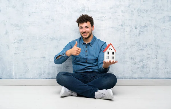 Joven Sentado Suelo Sosteniendo Una Casita —  Fotos de Stock