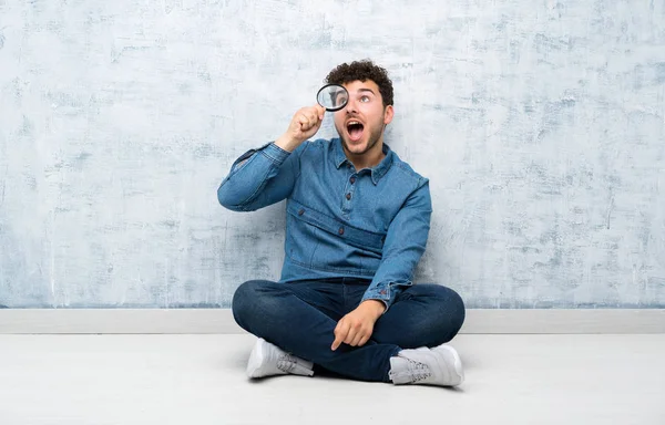 Jovem Sentado Chão Segurando Uma Lupa — Fotografia de Stock