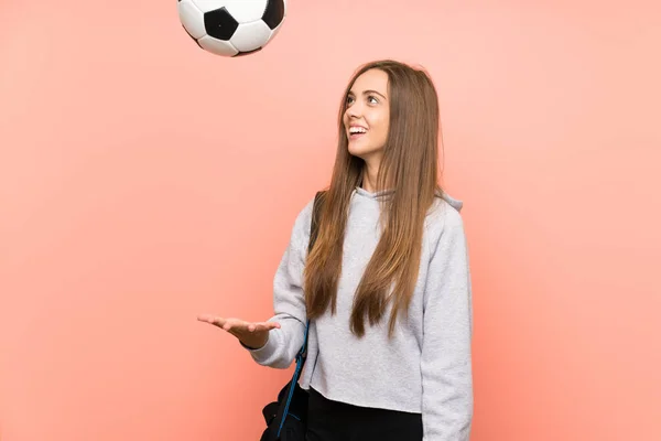 Felice giovane donna sport su isolato sfondo rosa che tiene un pallone da calcio — Foto Stock