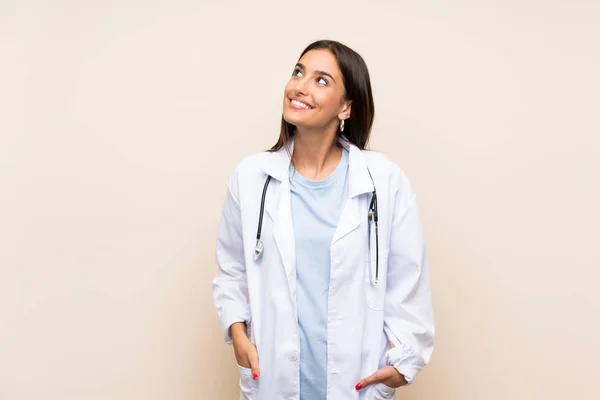 年轻的医生妇女在孤立的背景笑和抬头 — 图库照片
