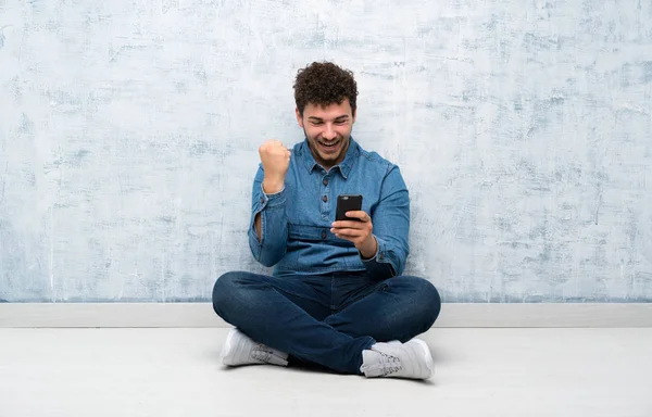 Junger Mann Sitzt Mit Handy Auf Dem Boden — Stockfoto