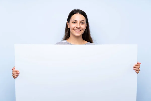 Jovem Morena Sobre Fundo Azul Isolado Segurando Cartaz Branco Vazio — Fotografia de Stock