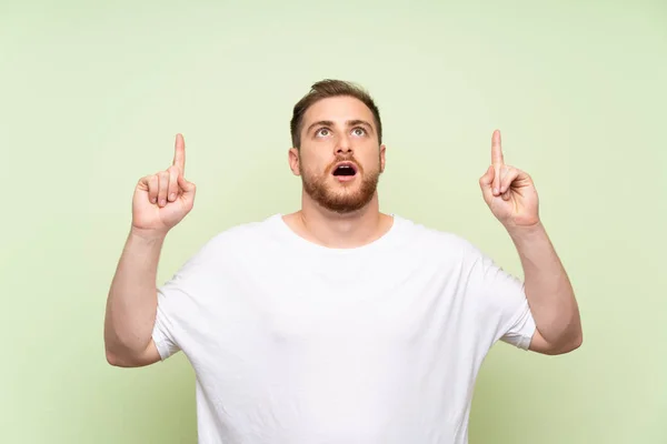 Hombre Guapo Sobre Fondo Verde Apuntando Con Dedo Índice Una — Foto de Stock