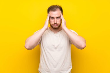 Sarı arka plan üzerinde yakışıklı adam mutsuz ve bir şey ile sinirli. Negatif yüz ifadesi