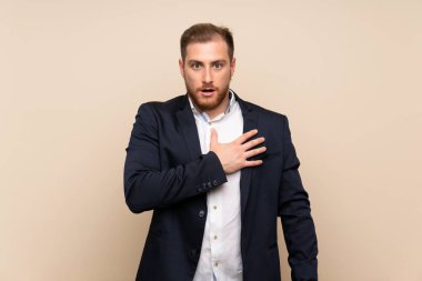 İzole arka plan üzerinde sarışın adam sürpriz ve doğru bakarken şok