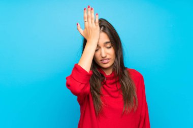 İzole mavi arka plan üzerinde kırmızı kazak ile genç kadın karıştırır yüz ifade ile şüpheler