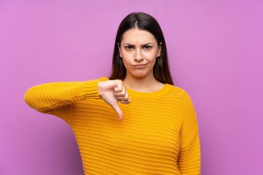 Izole mor arka plan üzerinde genç kadın başparmak aşağı işareti gösteren