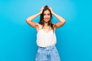 İzole mavi arka plan üzerinde genç kadın sinirli ve baş eller alır