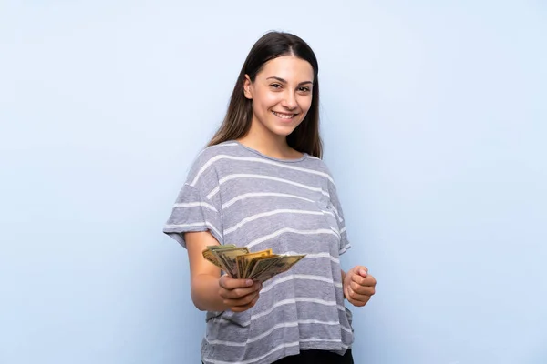 Joven Morena Sobre Aislado Fondo Azul Tomando Montón Dinero — Foto de Stock