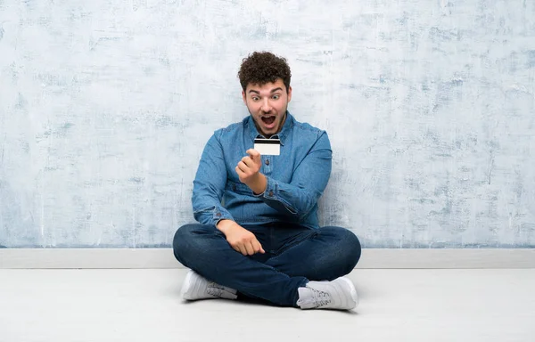 Jovem Sentado Chão Segurando Cartão Crédito — Fotografia de Stock