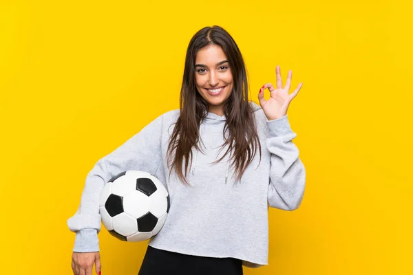 Młody Piłkarz Kobieta Białym Tle Żółte Tło Pokazując Znak Palcami — Zdjęcie stockowe