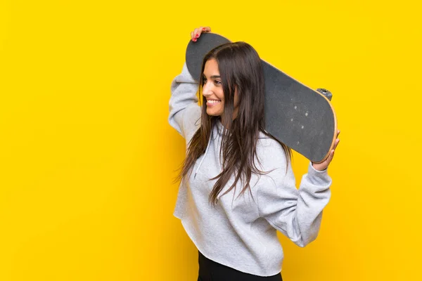 Wanita skater muda dengan latar belakang kuning yang terisolasi — Stok Foto